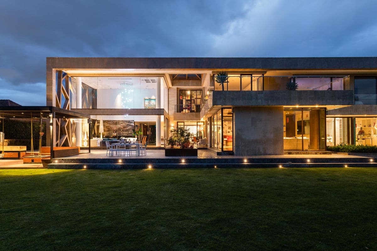 Modern residence illuminated with exterior and interior lighting at dusk